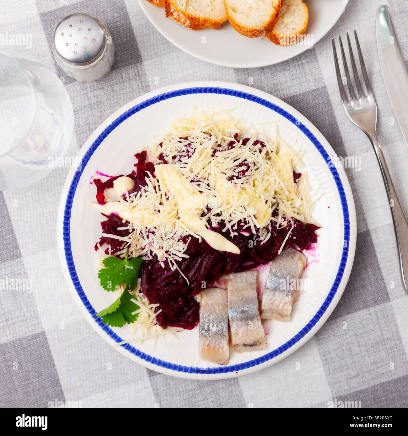 Sliced herring with grated beetroot and cheese served on table Stock Photo