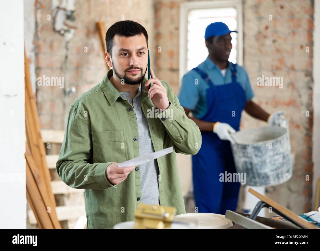 Architect talking on phone at construction site Stock Photo