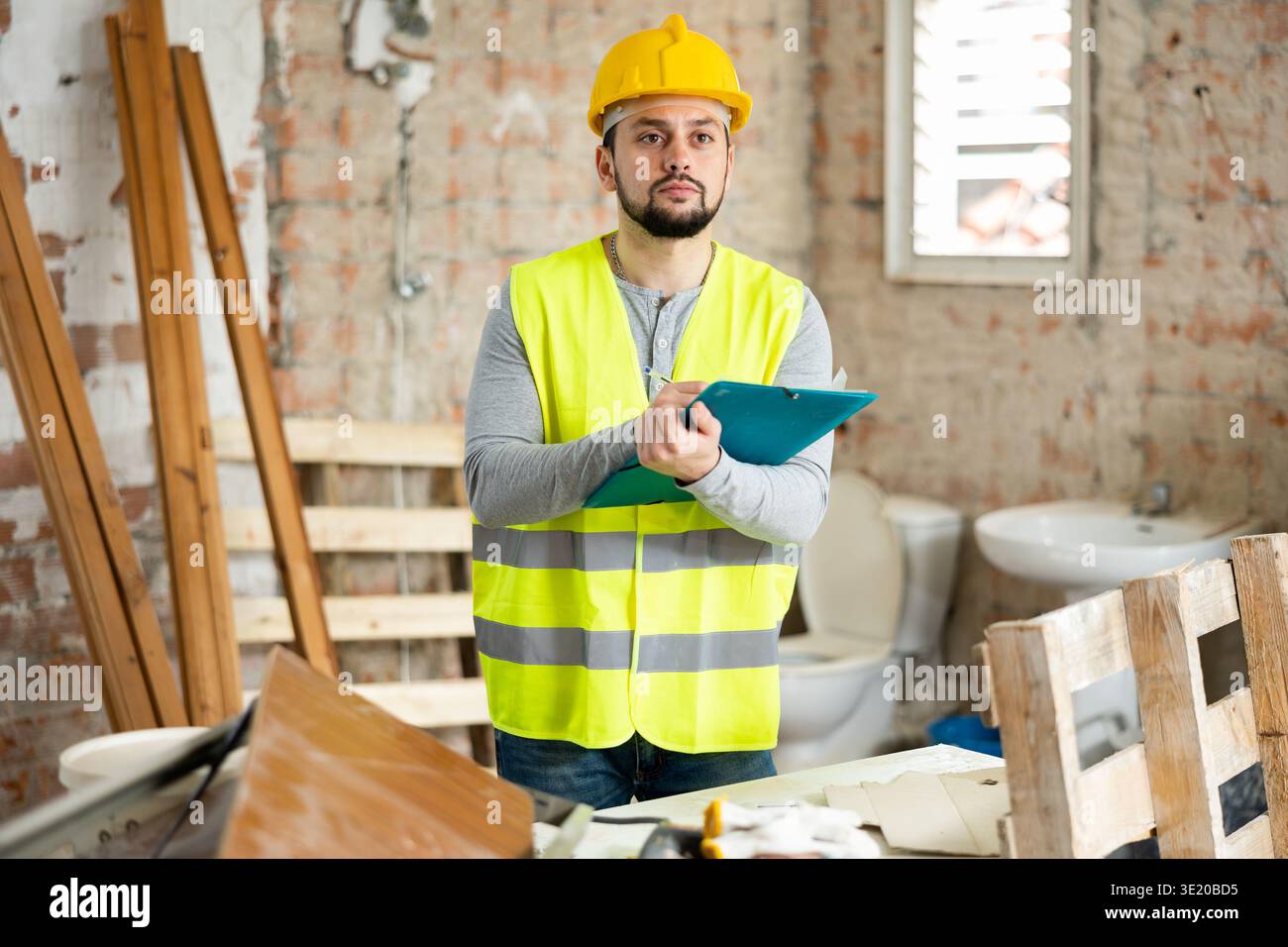 Builder making notes on indoor construction site Stock Photo
