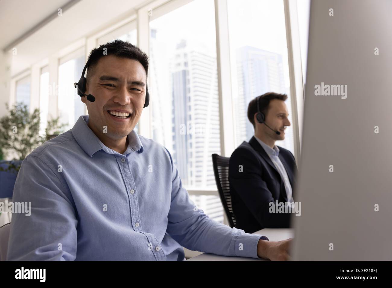 Young man customer service worker looking at camera with smile Stock Photo