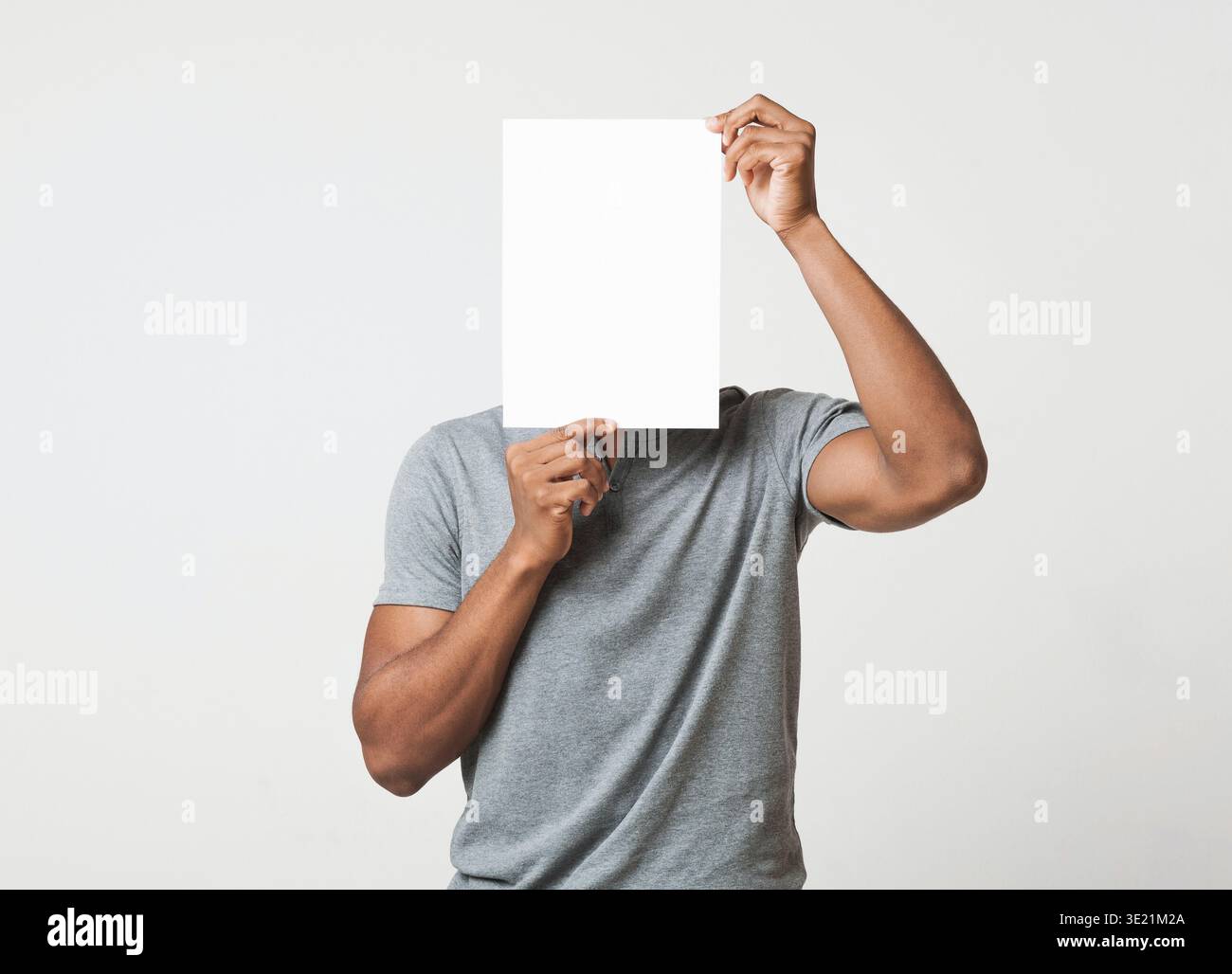 Man covering his face with empty white paper Stock Photo