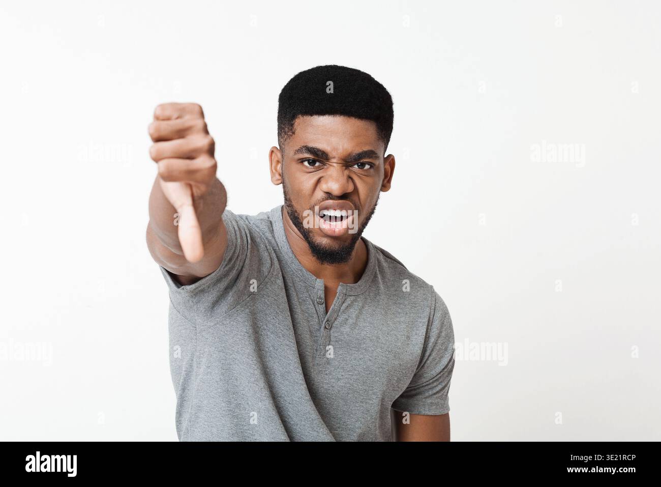 Angry man showing thumb down gesture as rejection symbol Stock Photo ...