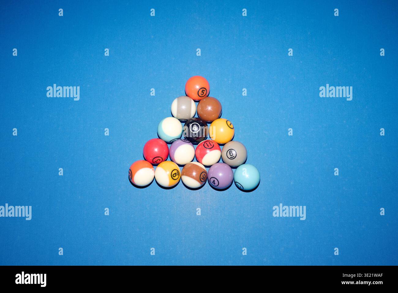 Billiard Balls Arranged in Triangle Formation on Blue Table Surface Stock Photo