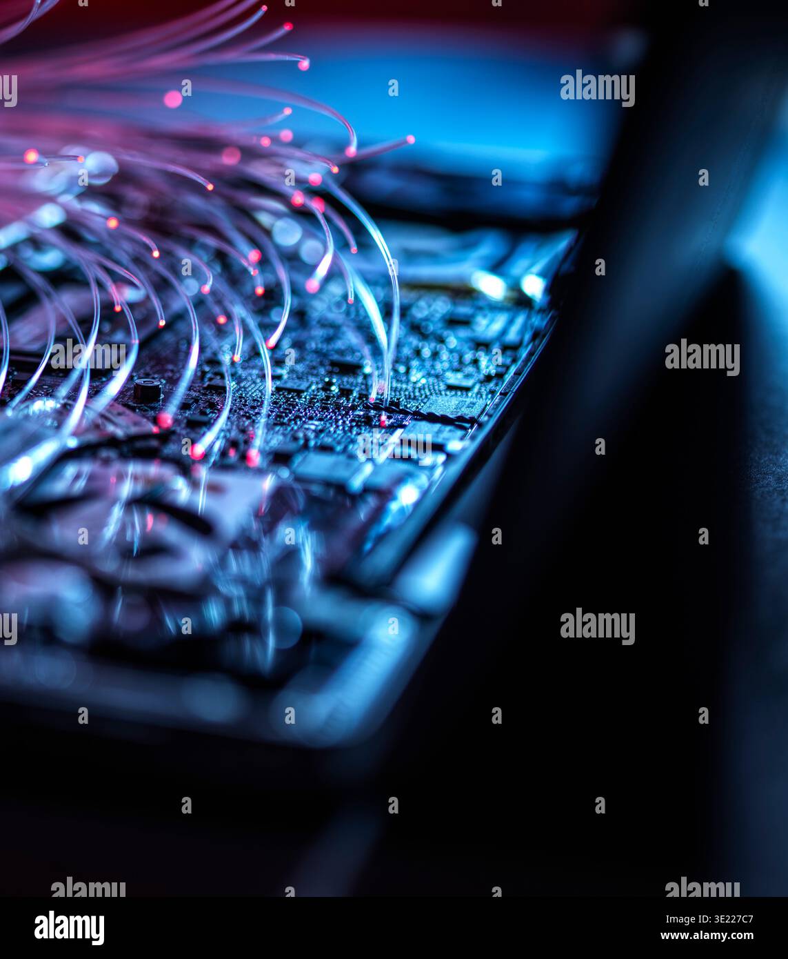 Fibre optics carrying data into a laptop computer Stock Photo