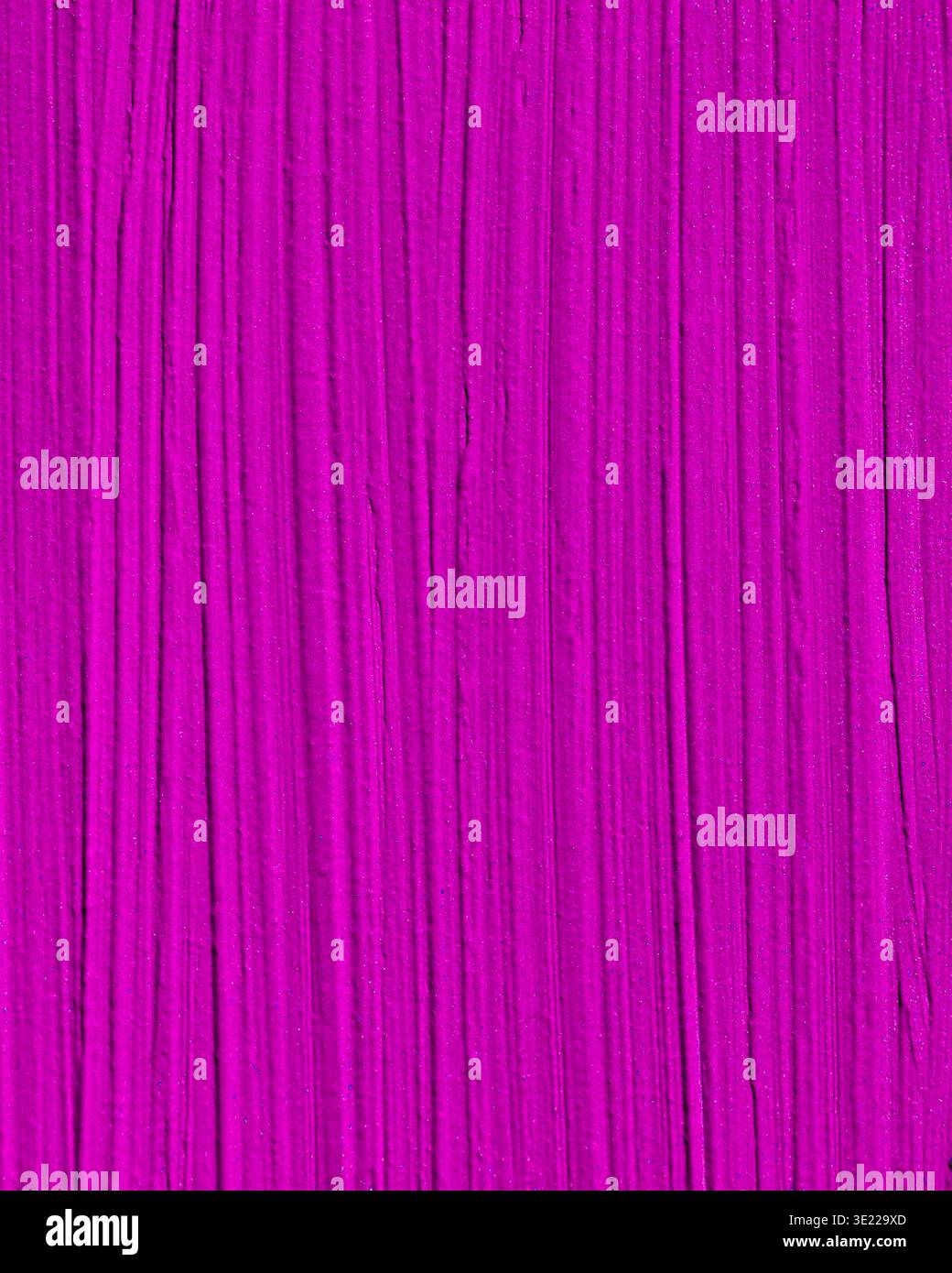 Abstract texture with vibrant magenta and vertical streaks creating a dynamic pattern. Stock Photo