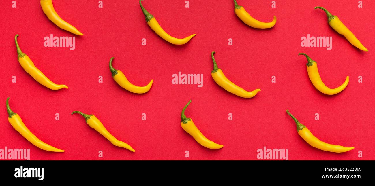 Hot yellow chilli peppers on red background Stock Photo