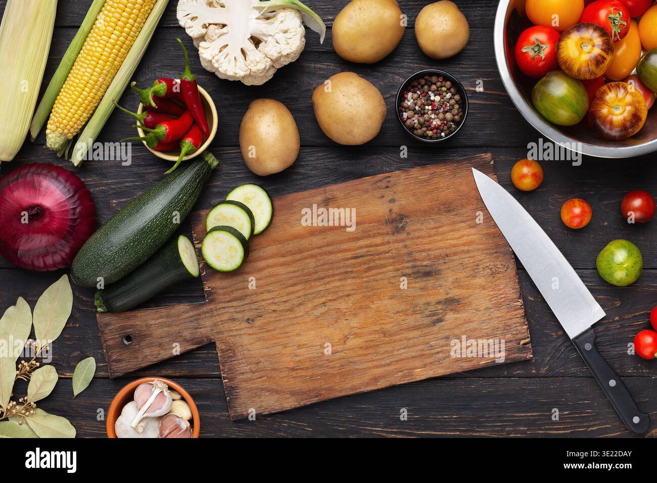 Vegetables assortment on kitchen table with cutting board Stock Photo