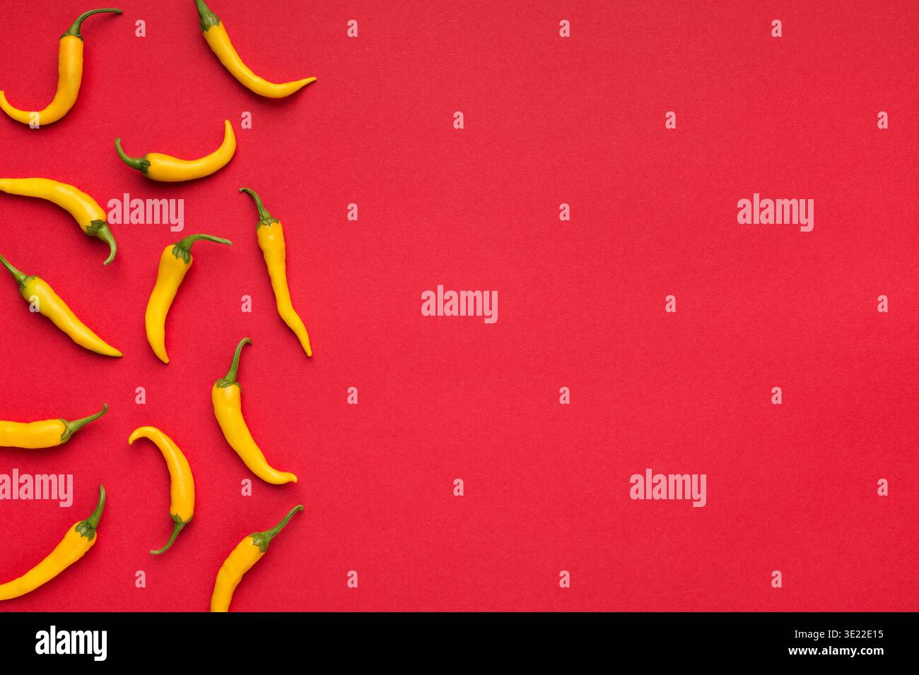 Hot yellow chilli peppers on red background Stock Photo