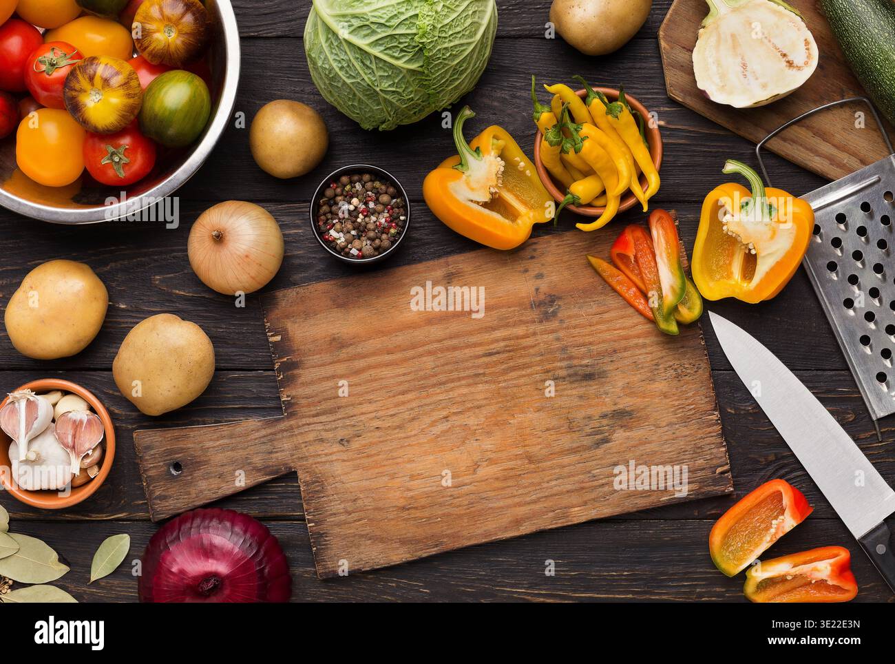 Vegetables assortment on kitchen table with cutting board Stock Photo