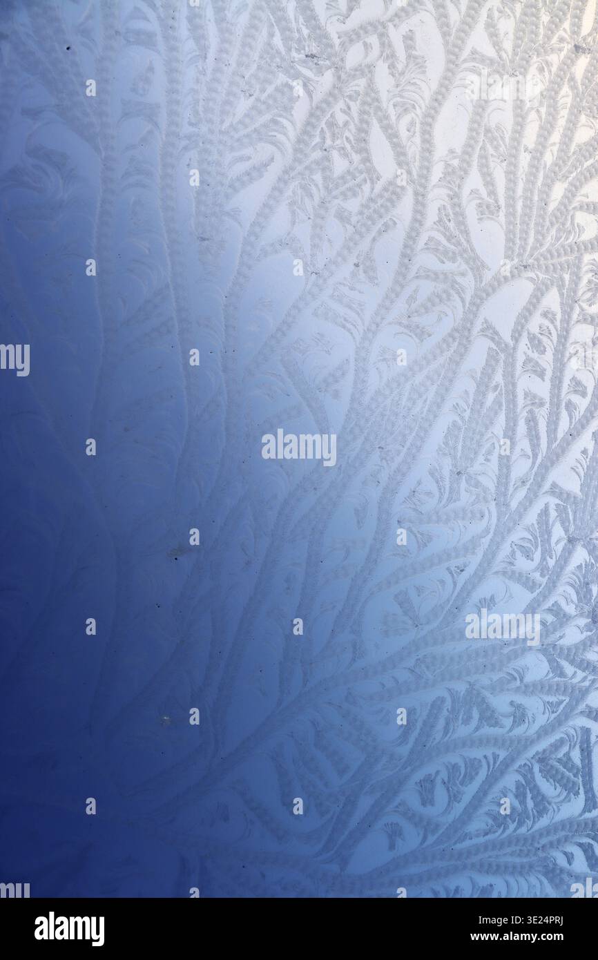 Hoarfrost forms an abstract ornament on a window pane Stock Photo