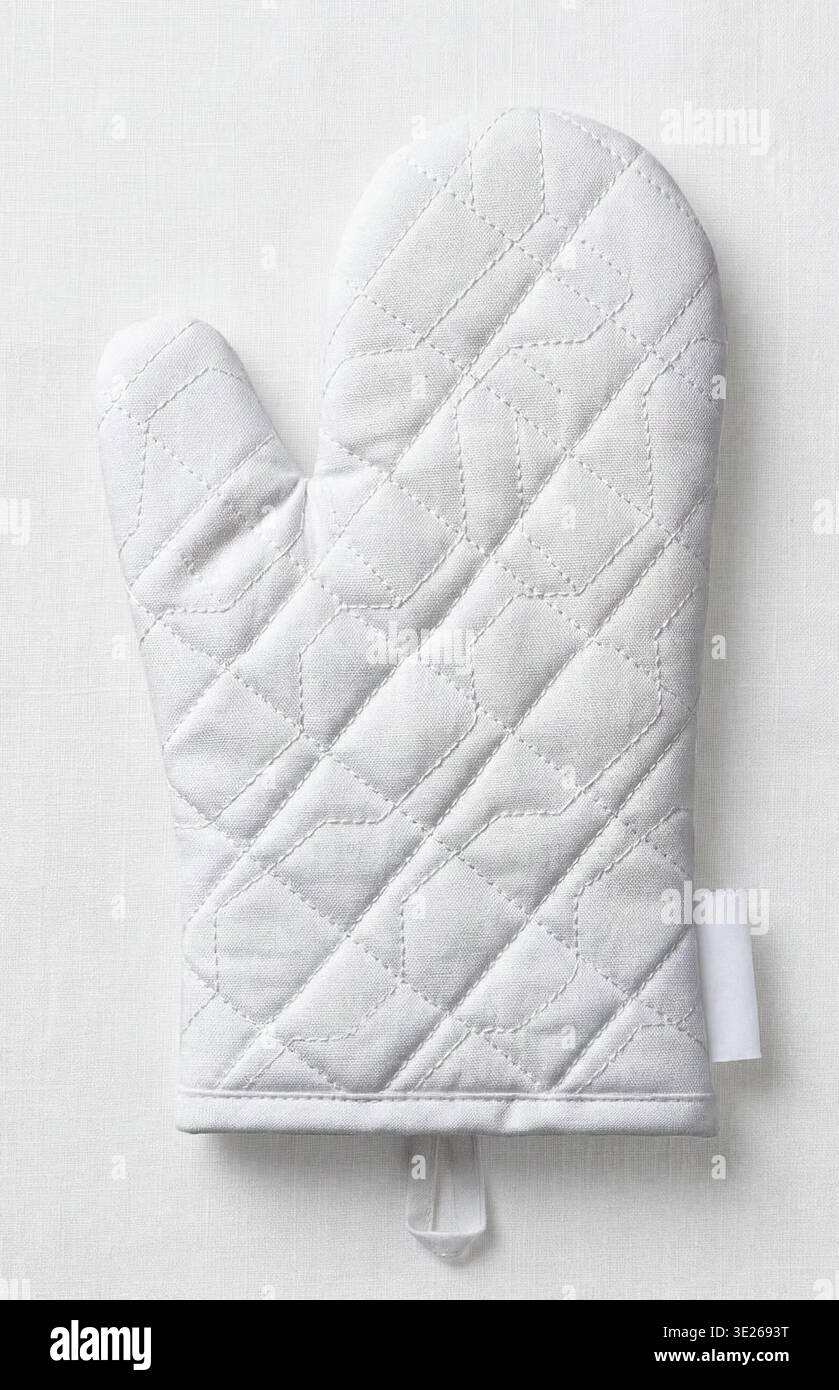Mockup of a white quilted oven mitt, top view, isolated on a white textile background. Stock Photo