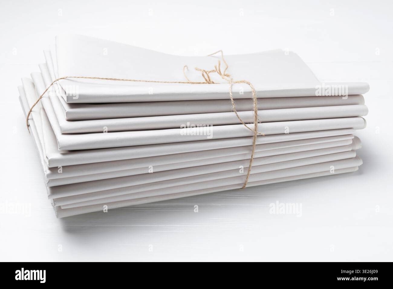 Stack of folded newspapers on white wooden table, closeup Stock Photo