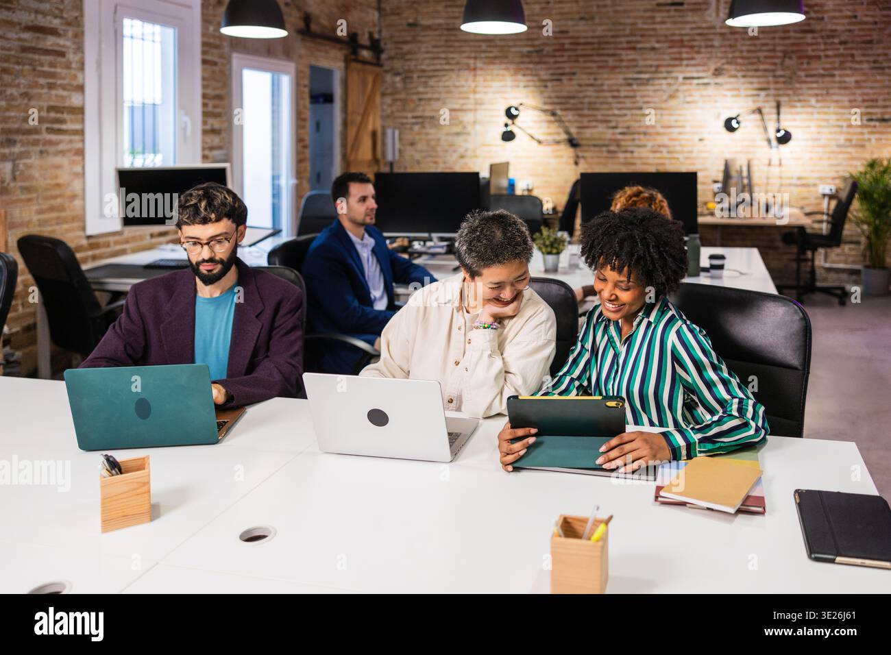 Multi ethnic team collaborating on project in modern office Stock Photo