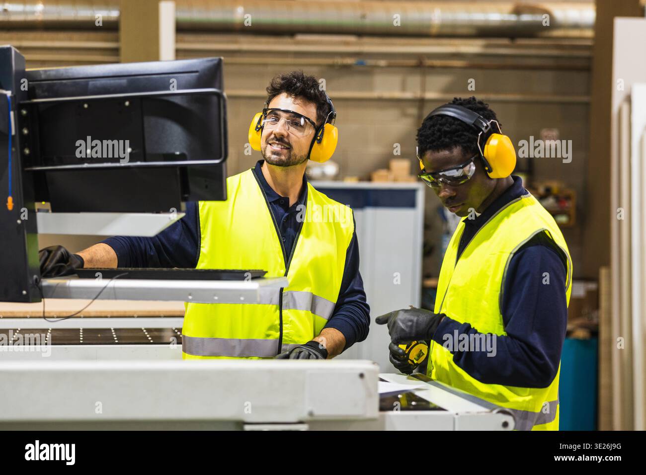 Millworkers operating cnc machine in carpentry workshop Stock Photo