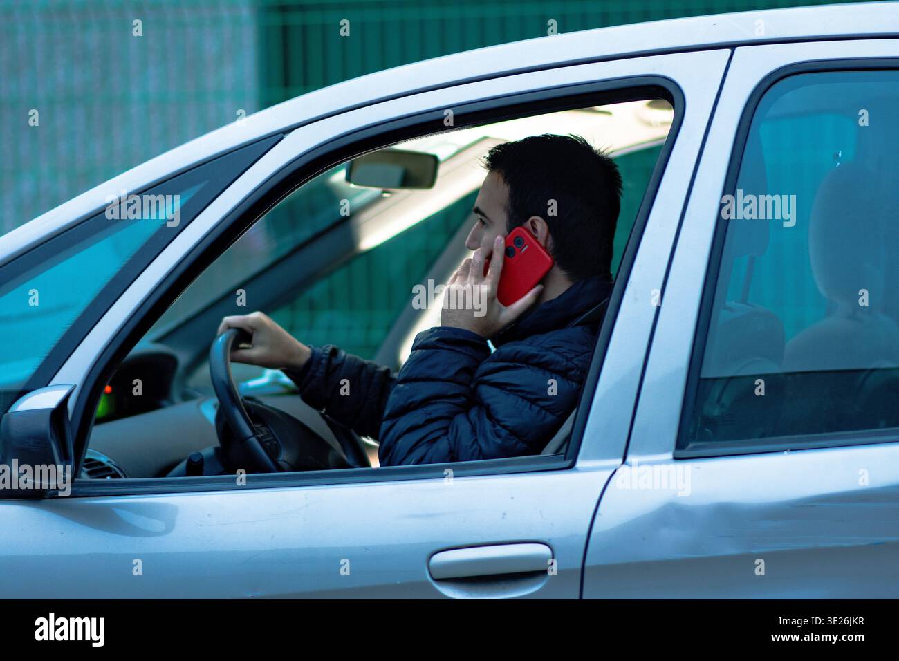 Man talking on mobile phone while driving car Stock Photo
