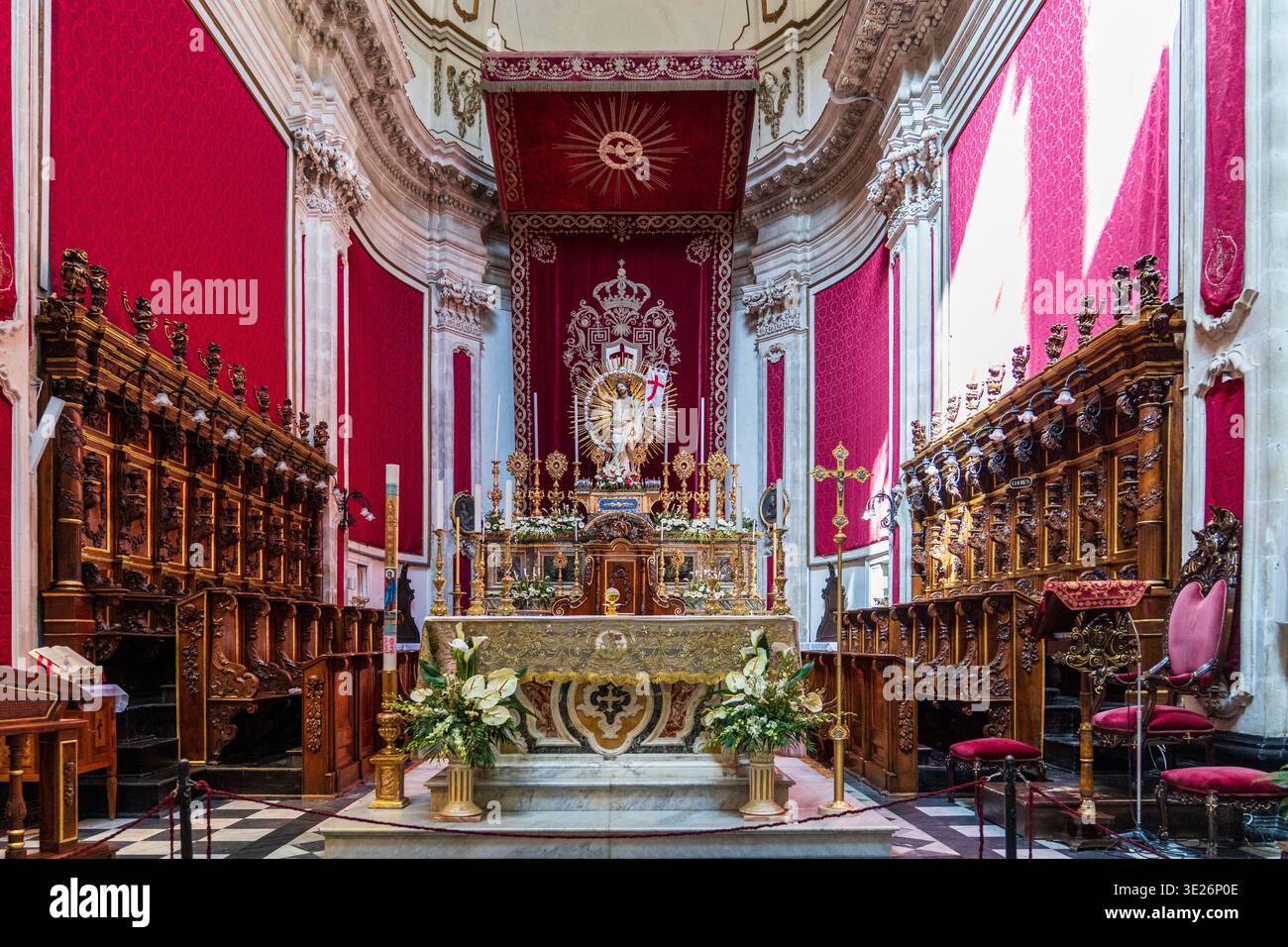 Interior of St. George's Cathedral in Ragusa Ibla. The Baroque altar is decorated with red drapes, gold, and flowers for the patronal feast. A masterp Stock Photo