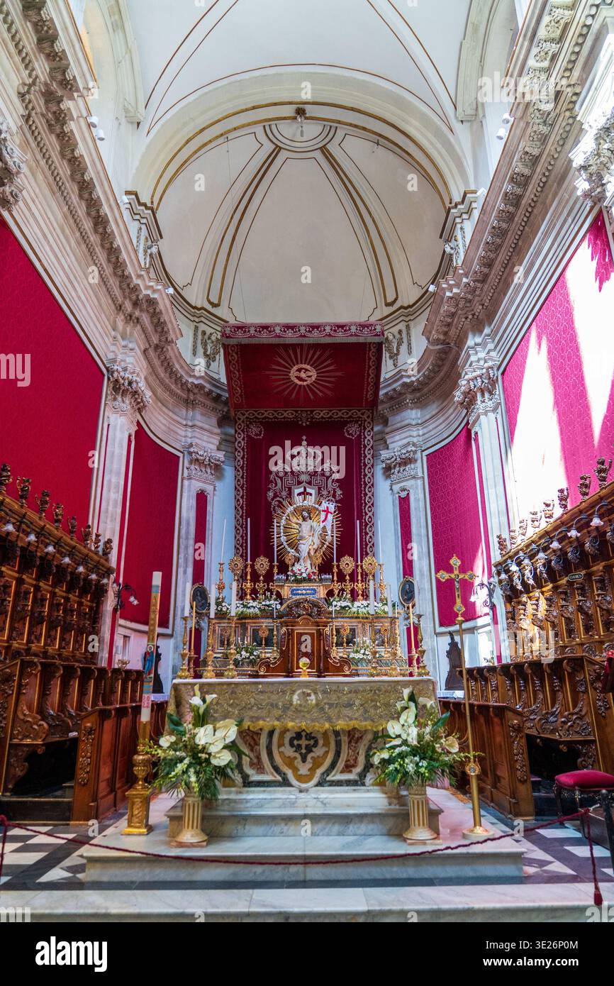 Interior of St. George's Cathedral in Ragusa Ibla. The Baroque altar is decorated with red drapes, gold, and flowers for the patronal feast. A masterp Stock Photo