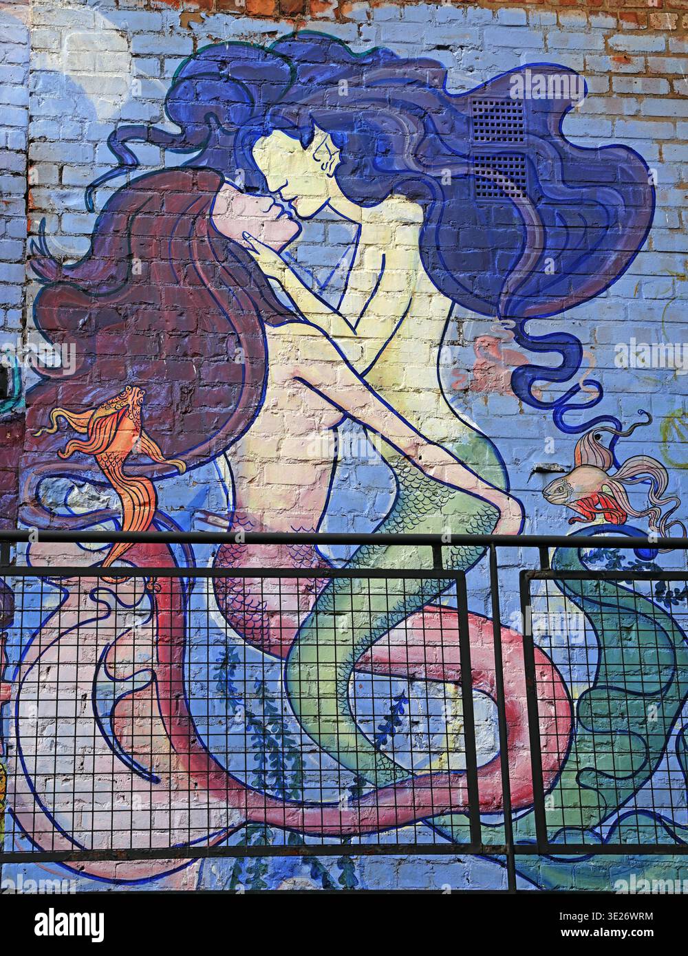 Mermaid street art mural on a brick wall in Liverpool city centre, Merseyside, England, showing a colourful romantic graffiti design. Stock Photo