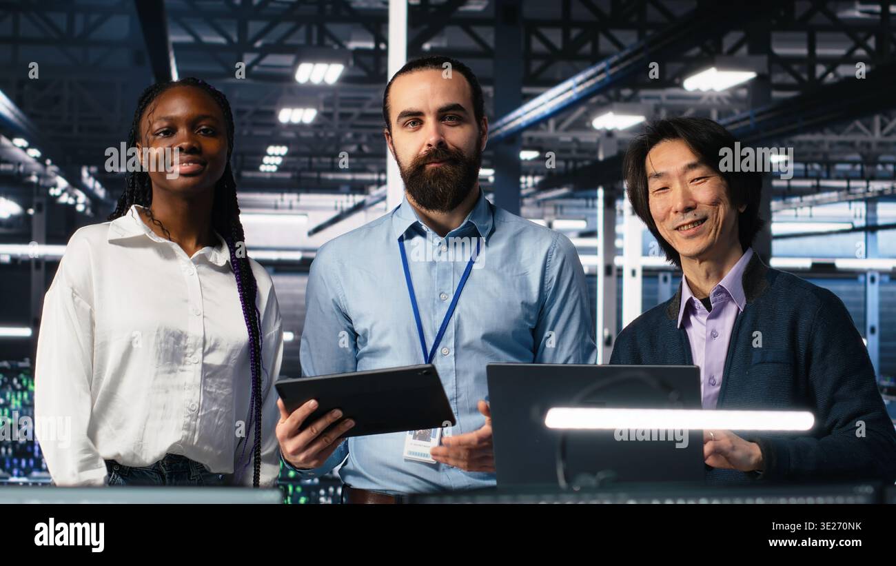 Happy data center colleagues collaborating on neural network software development. Cheerful teamworking server hub coworkers implementing machine learning technology in workplace, camera A Stock Photo