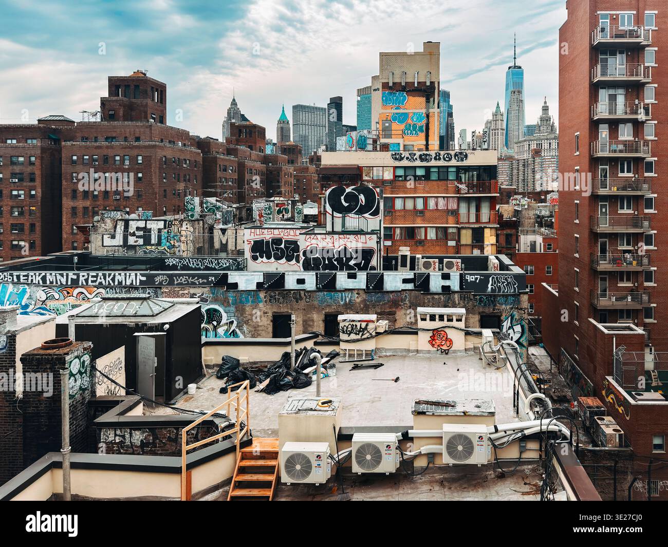 Graffiti-covered rooftops in Manhattan’s Chinatown with downtown skyline and One World Trade Center in the background Stock Photo