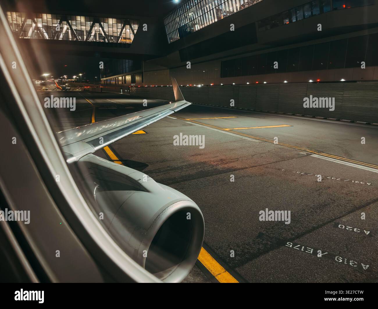 View of empty apron and terminal building from E175 jet window taxiing ...