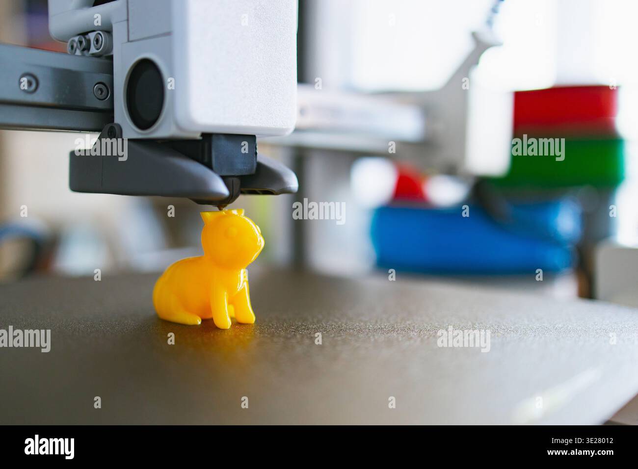 3D Printer Creating Yellow Cat Figurine Stock Photo