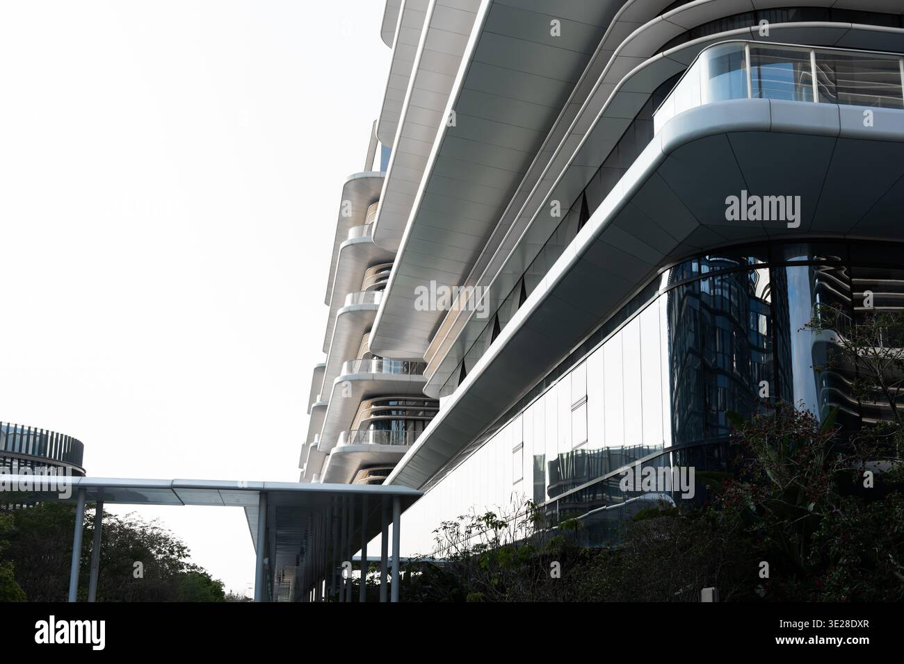 Modern futuristic building with curved glass facade and balconies in ...