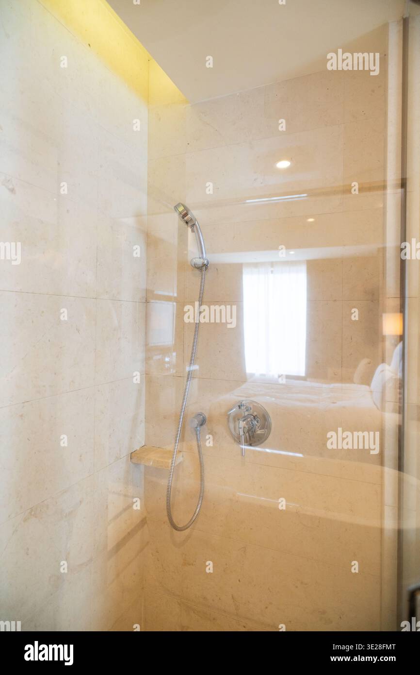 Modern marble shower with glass enclosure in luxury hotel bathroom, featuring ambient lighting and Stock Photo