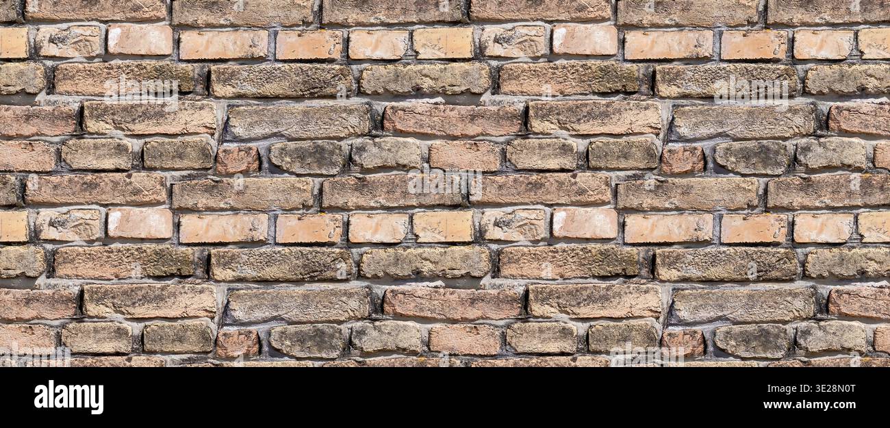 Rustic, aged brick wall texture. A seamless background featuring weathered brown and red bricks with dark mortar Stock Photo