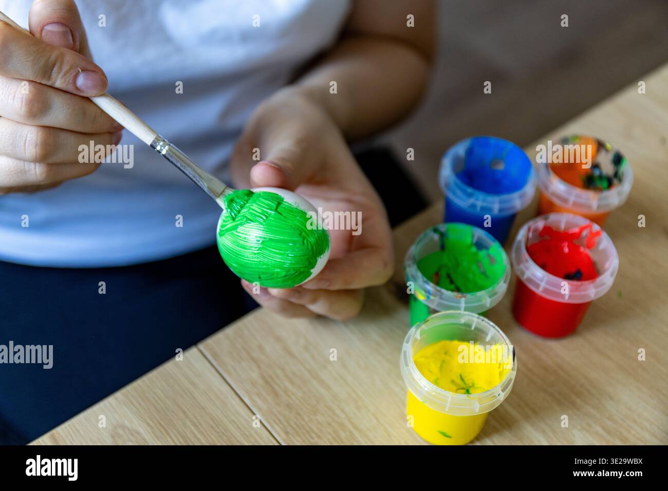 Woman is painting eggs preparing for Easter.  Stock Photo
