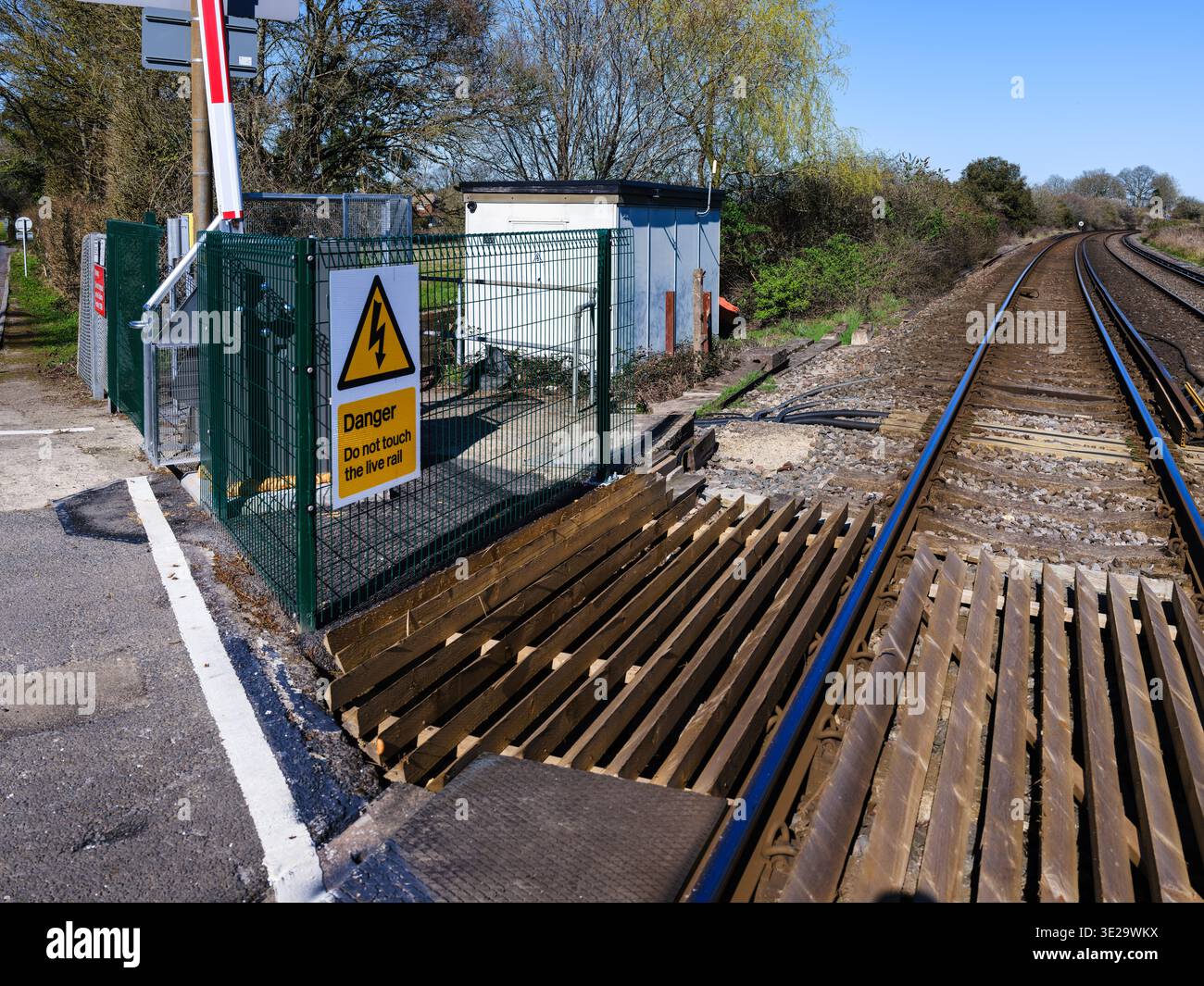 “Danger Rails” warning sign beside green metal fence and wooden sleeper ...