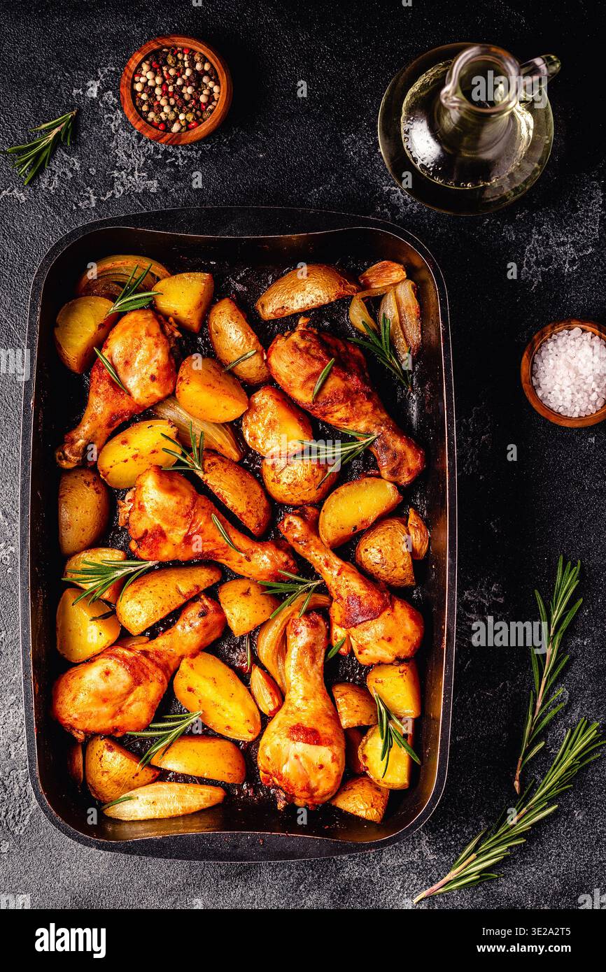 Roasted chicken legs with potatoes and rosemary. Top view. Stock Photo