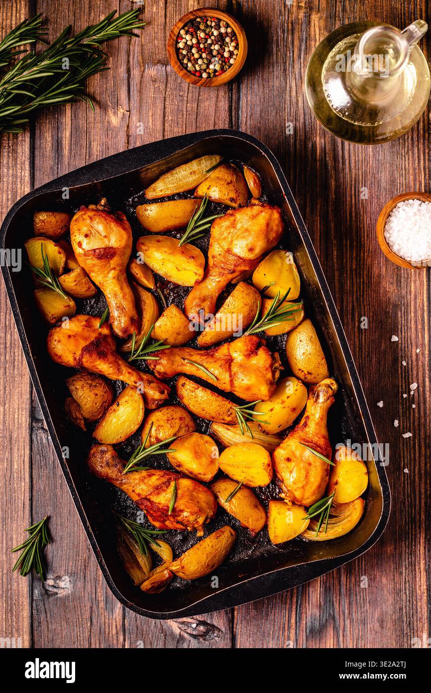 Roasted chicken legs with potatoes and rosemary. Top view. Stock Photo