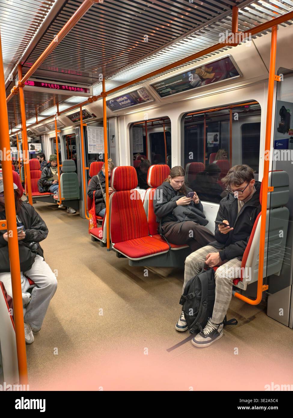 Prague, Czech Republic - March 19, 2026: Inside a Prague metro train carriage. Commuters and passengers sitting and using their smartphones during commute. Stock Photo