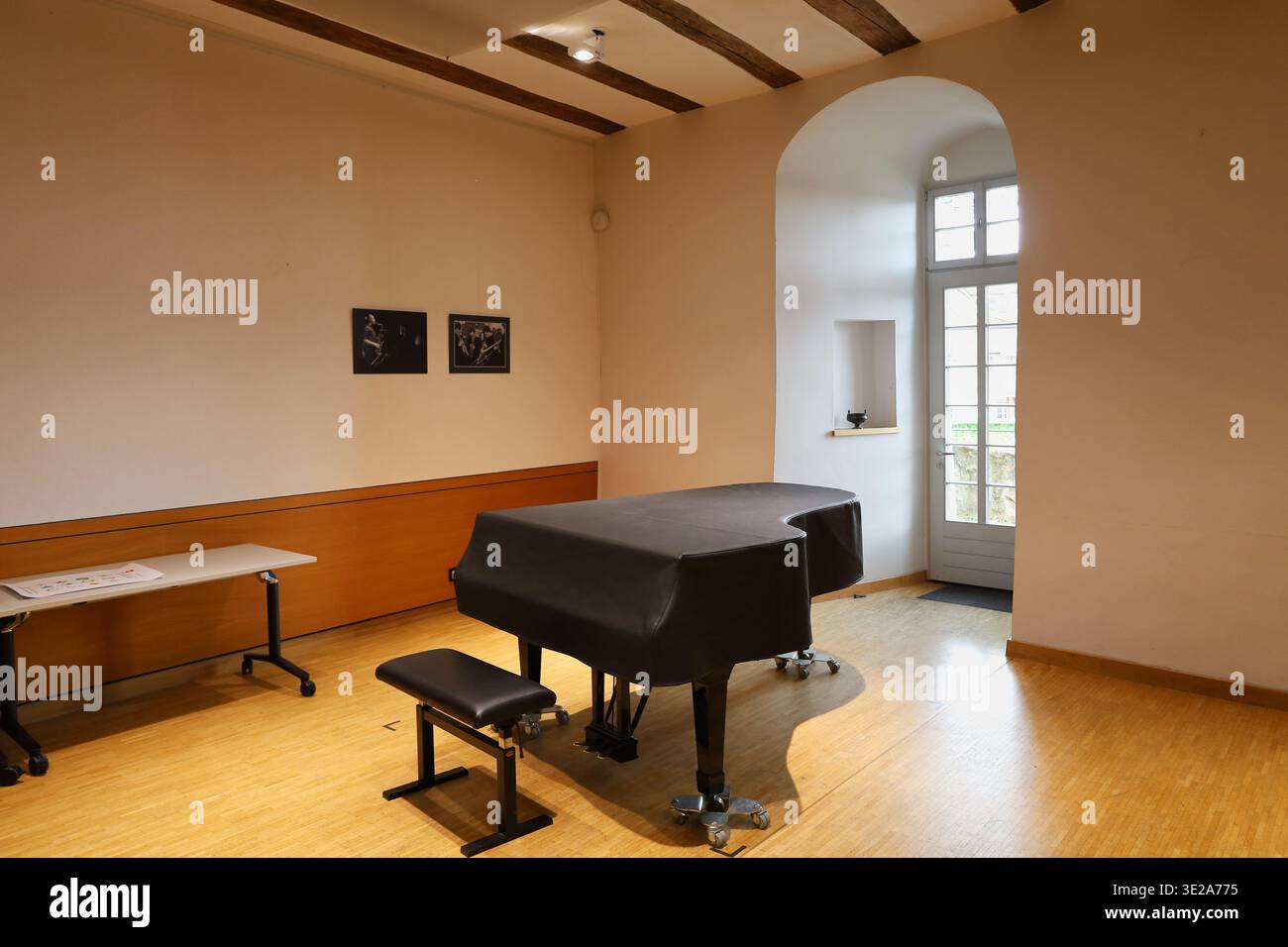 Übungsraum der Landesmusikakademie Sachsen in Schloss Colditz mit schwarzem Flügel, Holzbalkendecke und hellem Parkett in Mittelsachsen Stock Photo