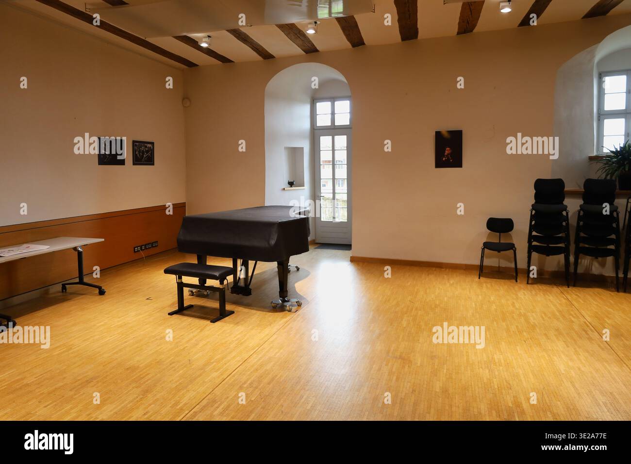 Übungsraum der Landesmusikakademie Sachsen in Schloss Colditz mit schwarzem Flügel, Holzbalkendecke und hellem Parkett in Mittelsachsen Stock Photo