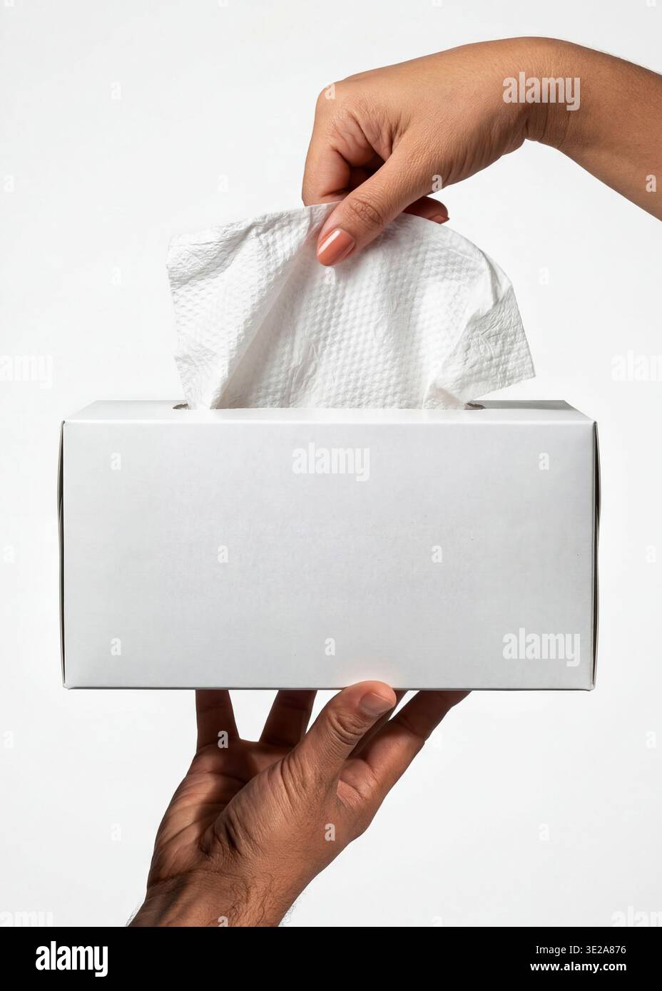 Mockup of a white rectangular tissue box, held by hands with a tissue being pulled out. Stock Photo