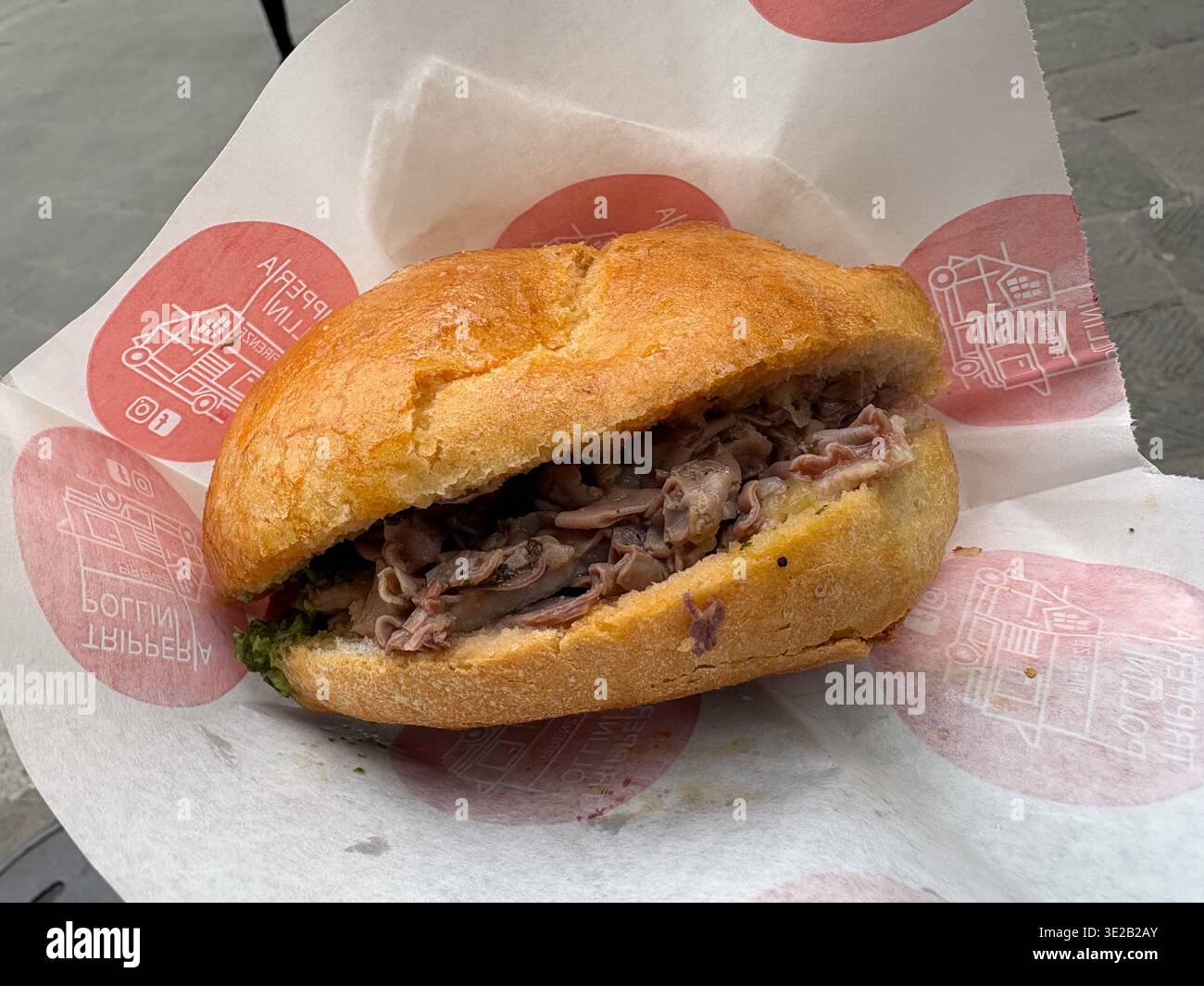Lampredotto sandwich. Panino al lampredotto. Florence, Italy. Iconic Florentine street food specialty made from cow's fourth stomach, served on bread. Stock Photo