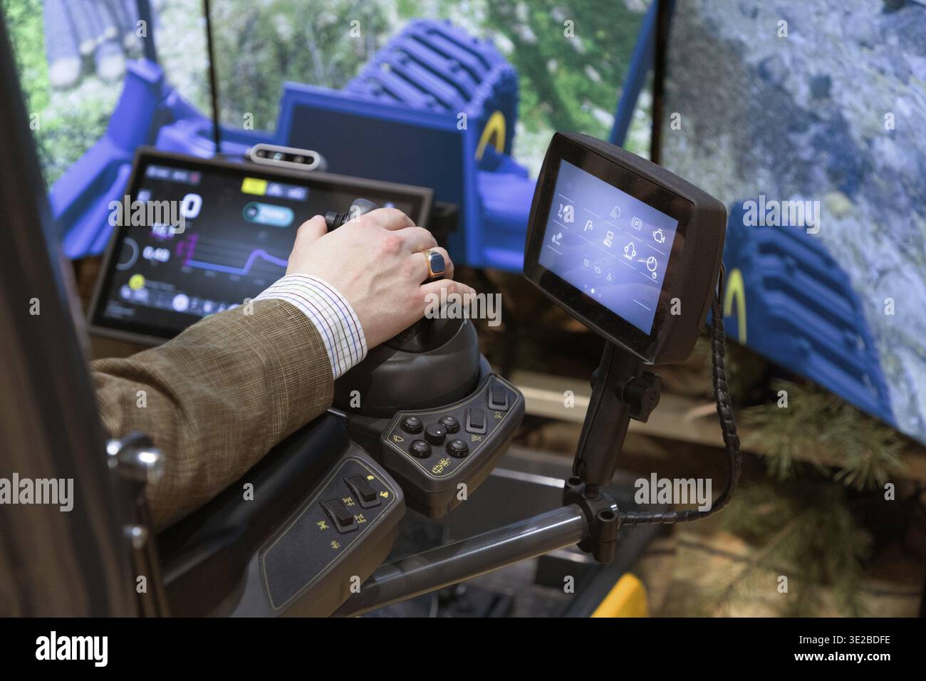 Berlin, Germany - January 22, 2024: Operator is using advanced machinery control panel with multiple screens displaying operational data Stock Photo
