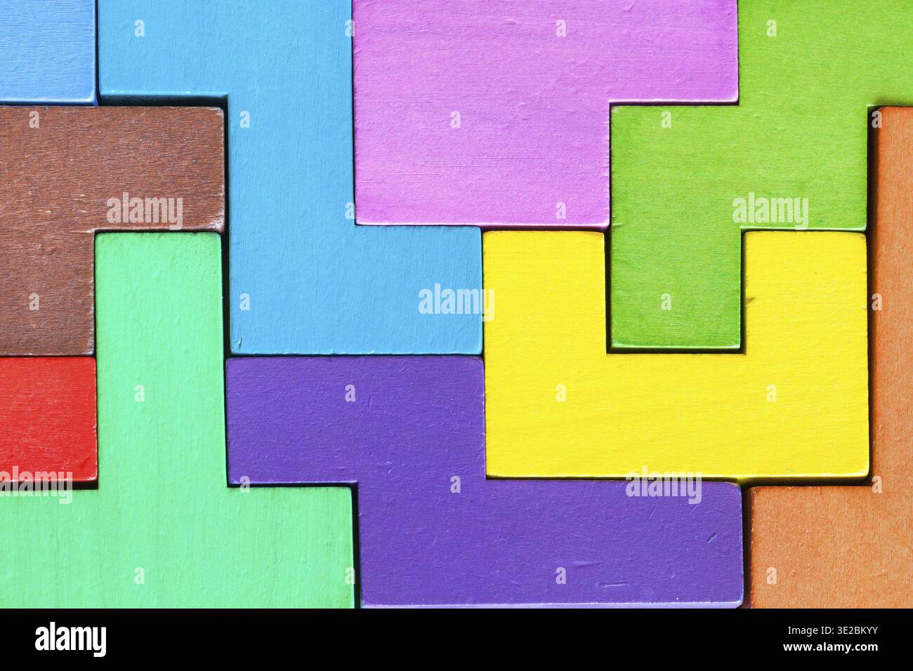 Surface of assembled puzzle from colored wooden pentominoes and blocks ...