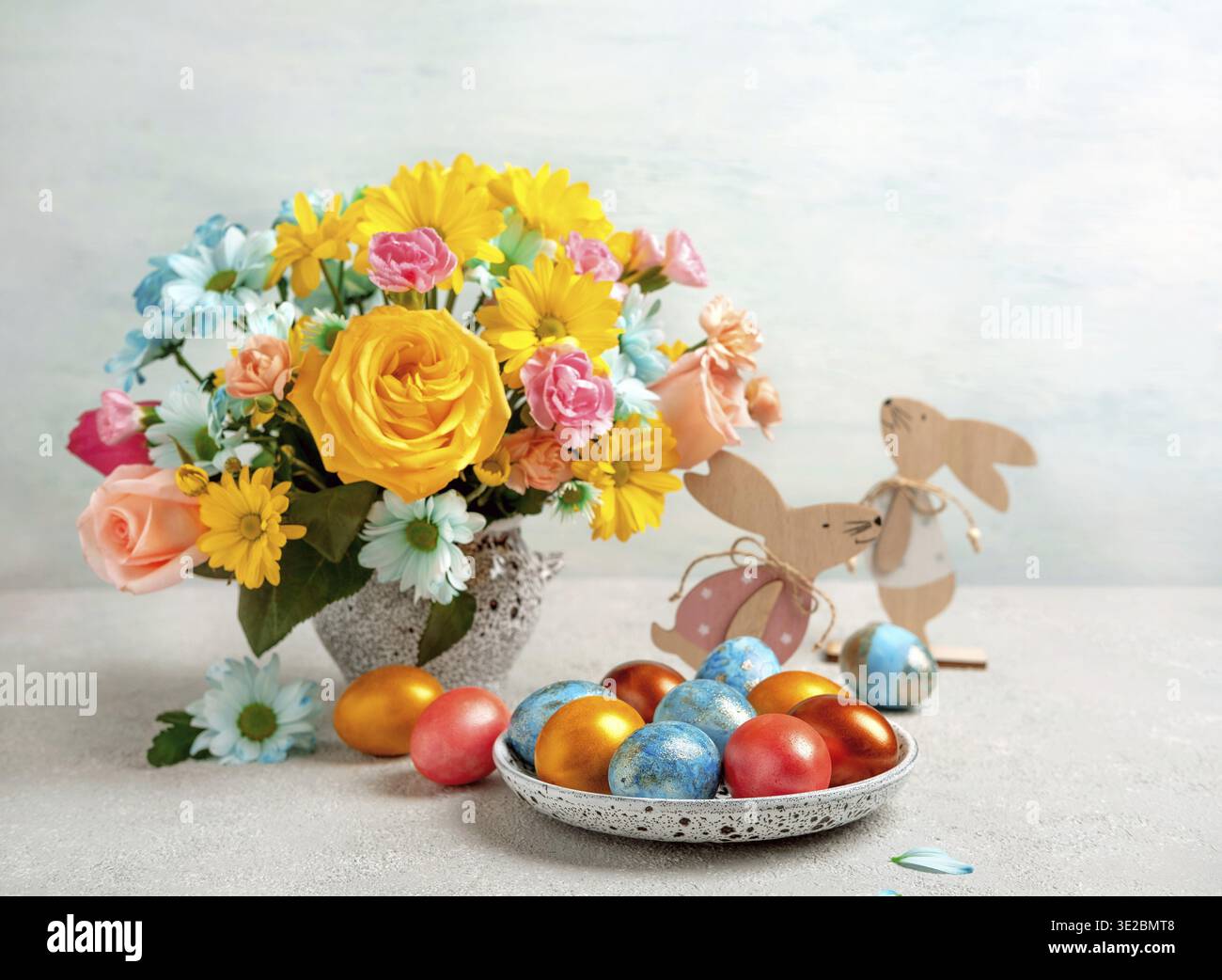 Easter eggs, easter rabbit and spring flowers, space for text. Happy Easter. Congratulatory easter background Stock Photo