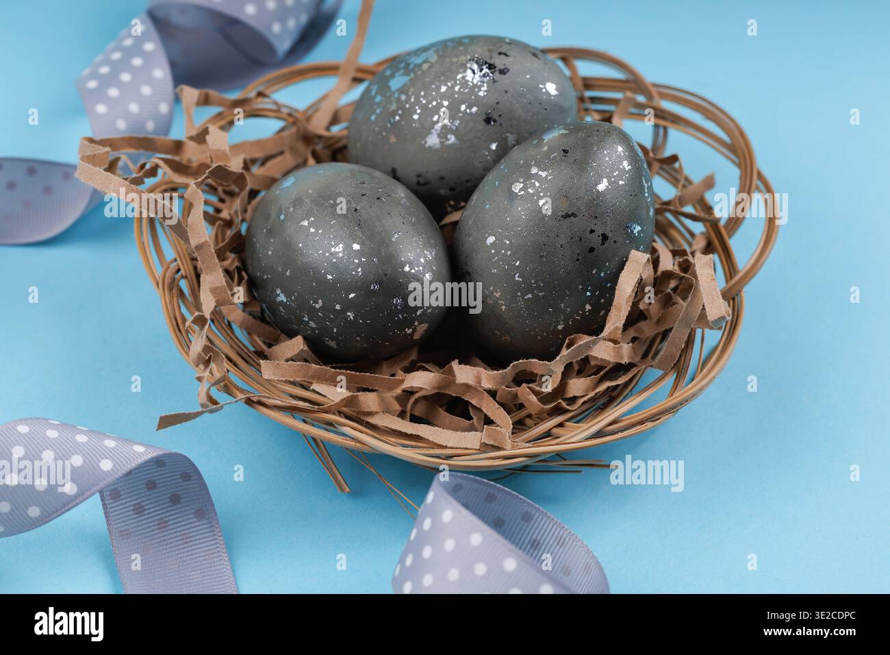 Speckled Easter eggs with silver texture in nest Stock Photo