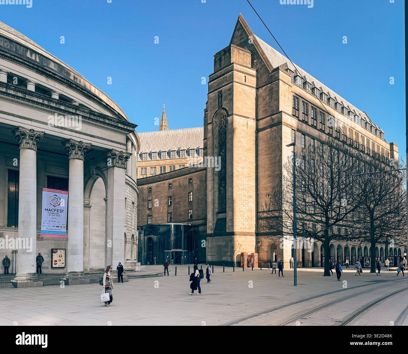 Early morning and blue sky with the sun stretching out over the town hall and central library in Manchester City Centre Stock Photo
