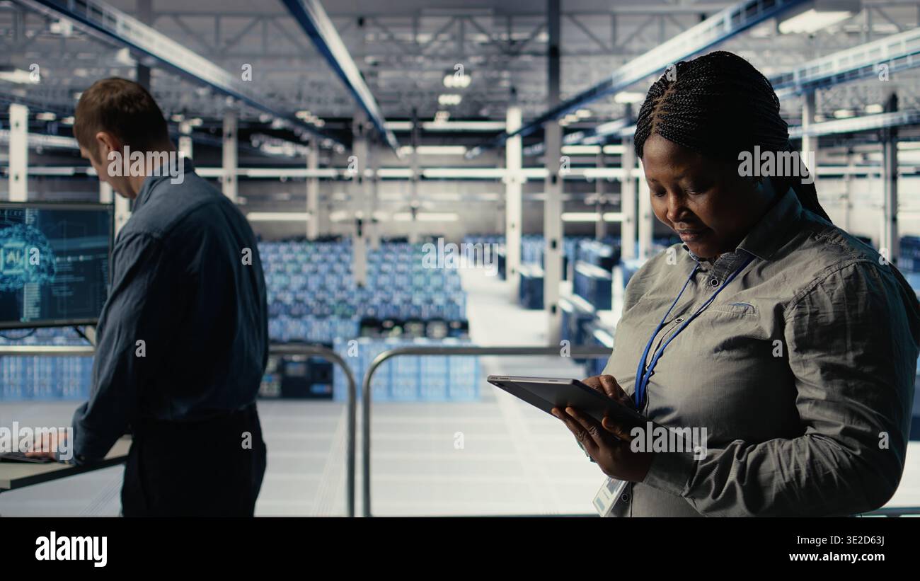Teamworking data center programmers investigate neural networks configuration, making adjustments for optimal function. Server hub colleagues work together to check deep learning errors, camera A Stock Photo