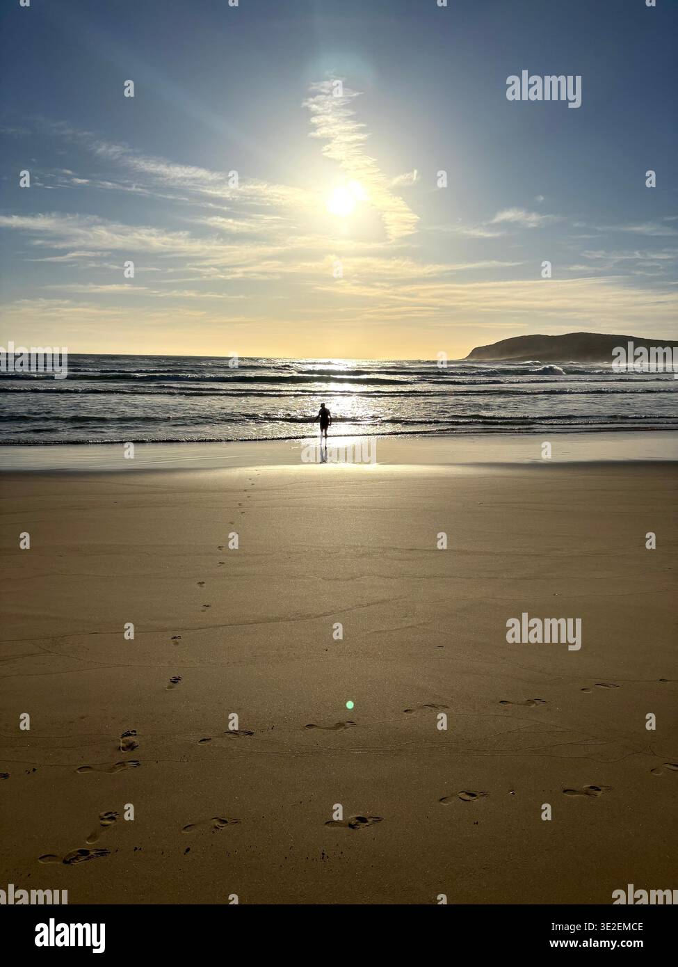 Lone Silhouette Figure Standing at Sunset on Wild South African Beach - Smartphone Captured Stock Image