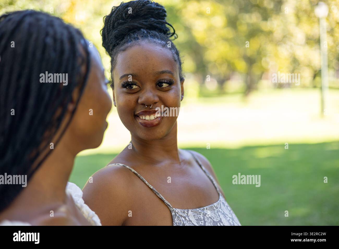 Black siblings interacting outside in a park Stock Photo