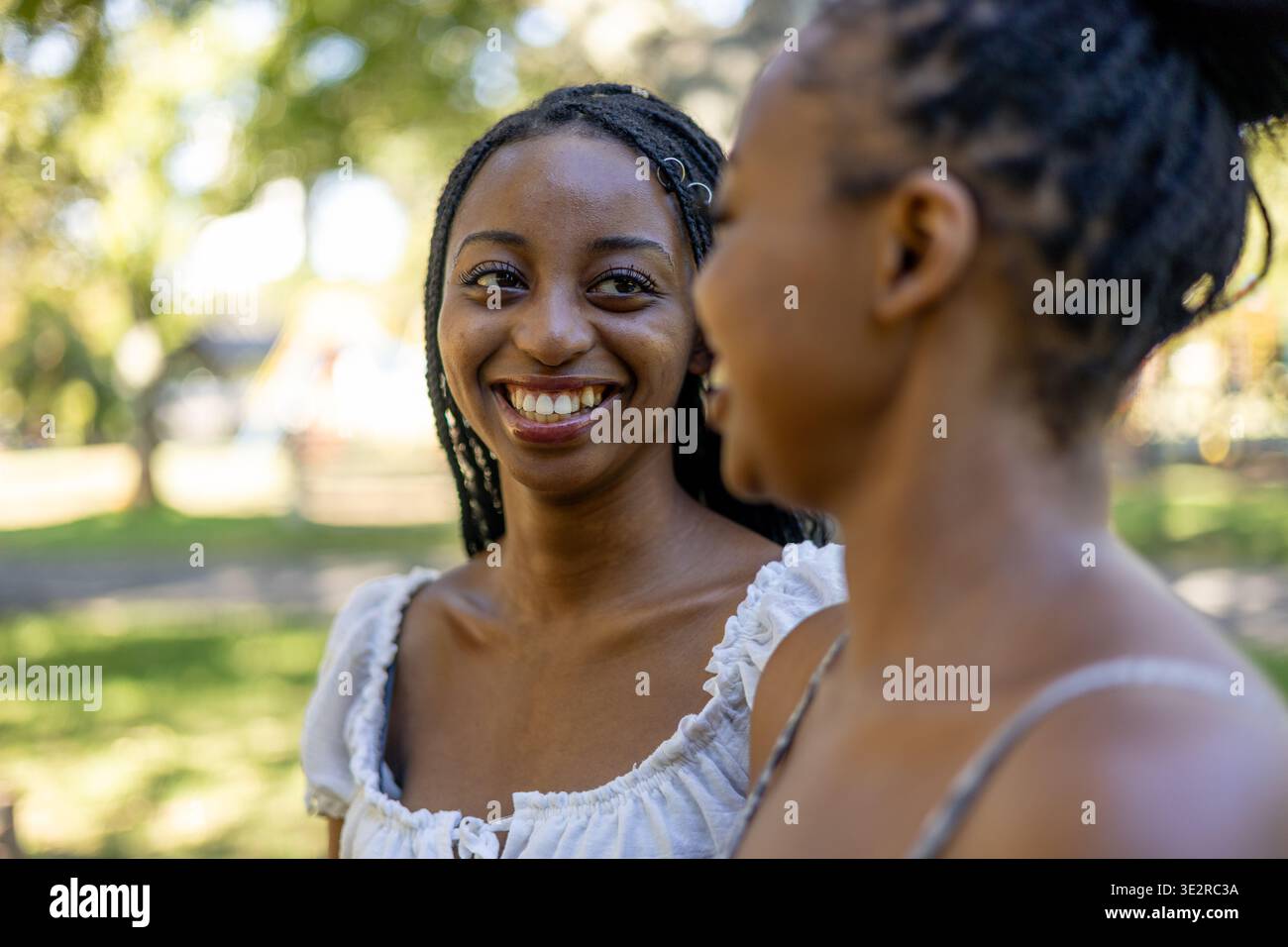 Black siblings interacting outside in a park Stock Photo