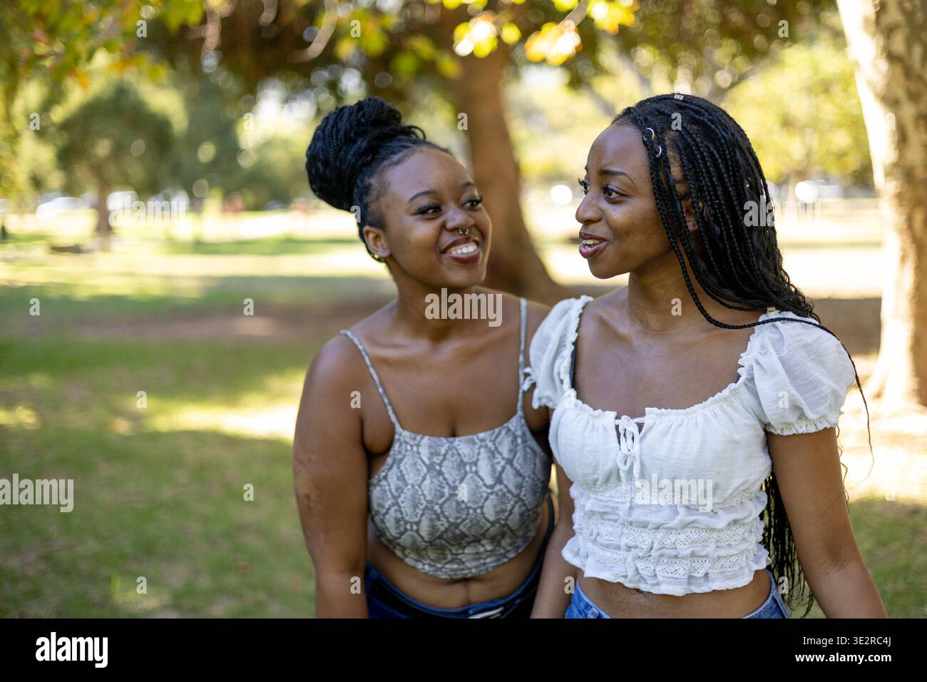 Black siblings interacting outside in a park Stock Photo