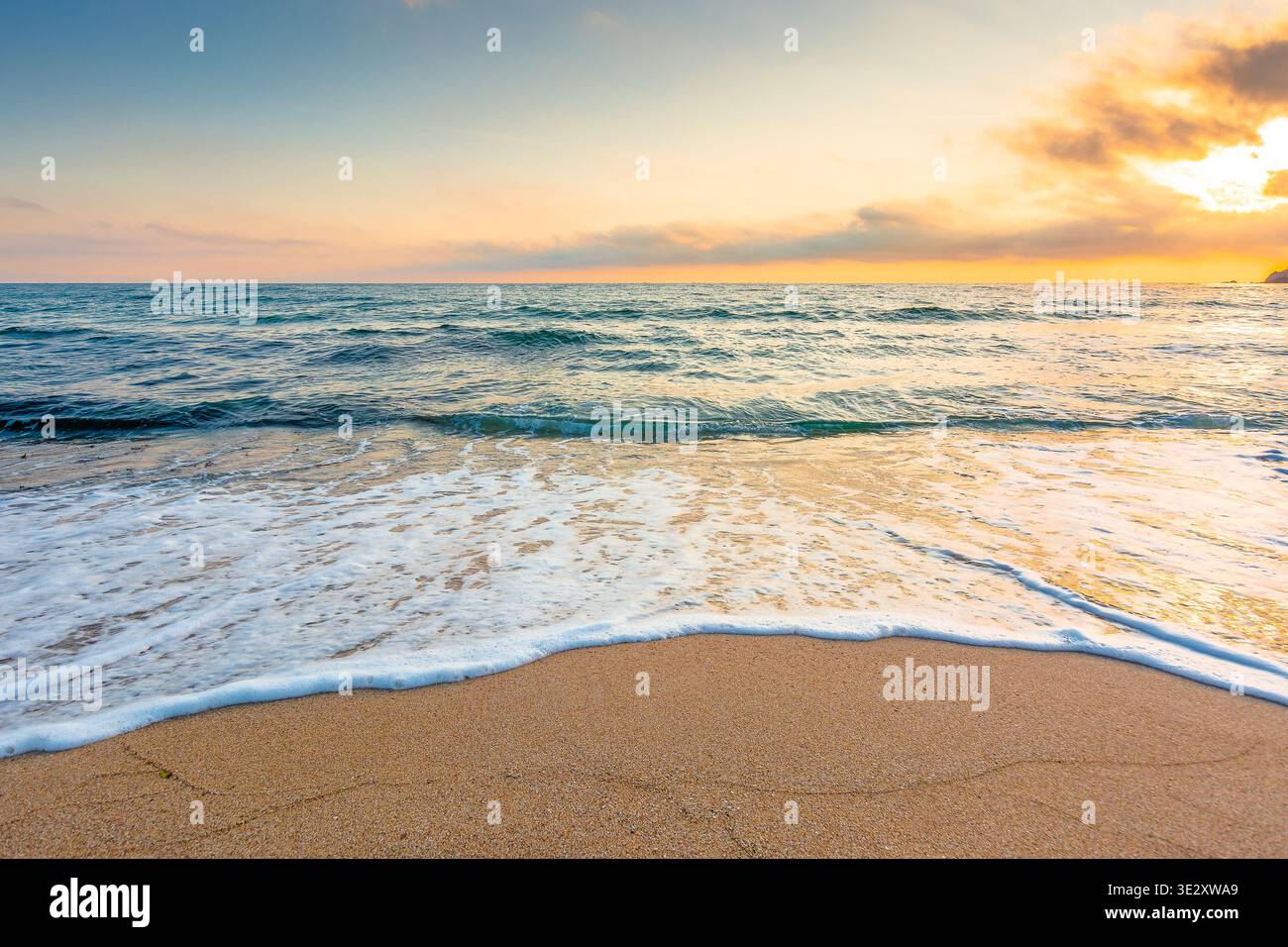 autumn vacation at the sea. beautiful seascape at sunrise. calm waves wash the sandy beach. image with fluffy clouds on the sky above horizon. perfect Stock Photo