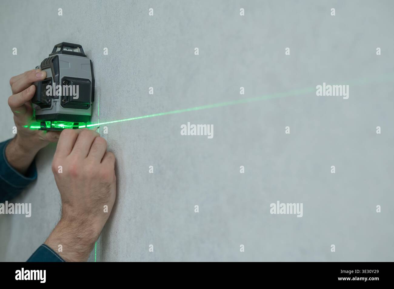 A man measures distance with a laser level.  Stock Photo